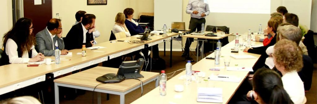 un formatore illustra ai corsisti seduti al tavolo i punti del corso di formazione specifica