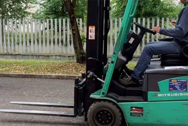 formatore illustra in strada i movimenti del carrello elevatore