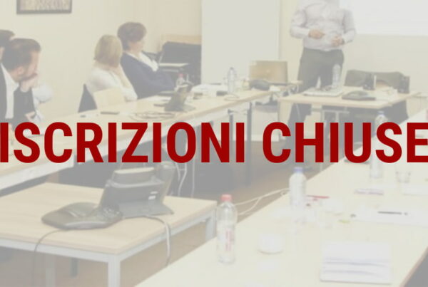 un formatore illustra ai corsisti seduti al tavolo i punti del corso di formazione specifica